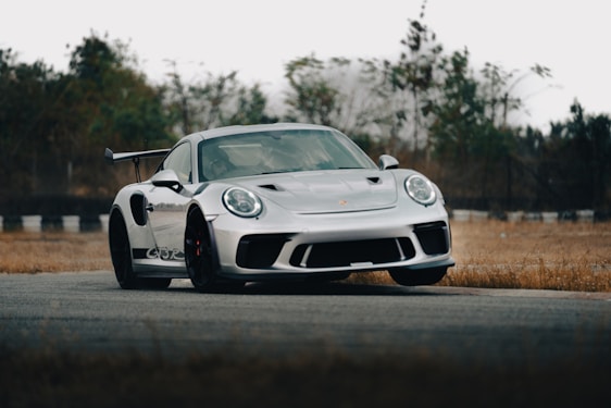 A sleek sports car showcasing custom aerodynamic components on a racetrack.