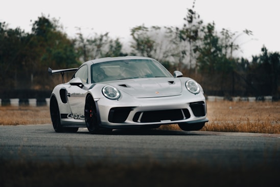 A sleek sports car showcasing custom aerodynamic components on a racetrack.