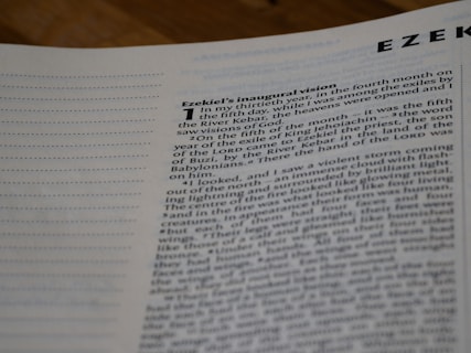 A close-up view of an open book showing the beginning of a chapter titled 'Ezekiel's inaugural vision'. The text describes a vision experienced by the prophet Ezekiel.
