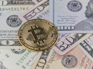 a bitcoin sitting on top of a pile of money