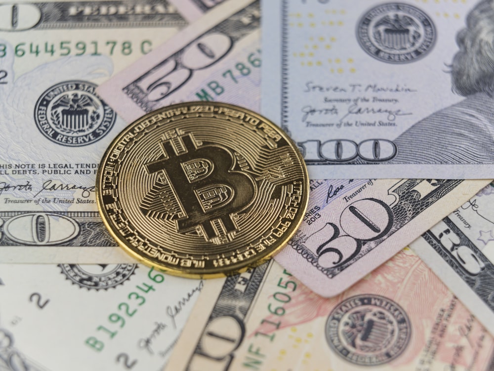 um bitcoin sentado em cima de uma pilha de dinheiro