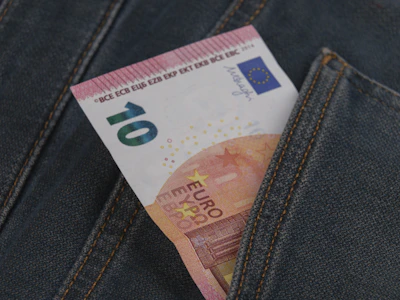 a money bill sticking out of the back pocket of a pair of jeans