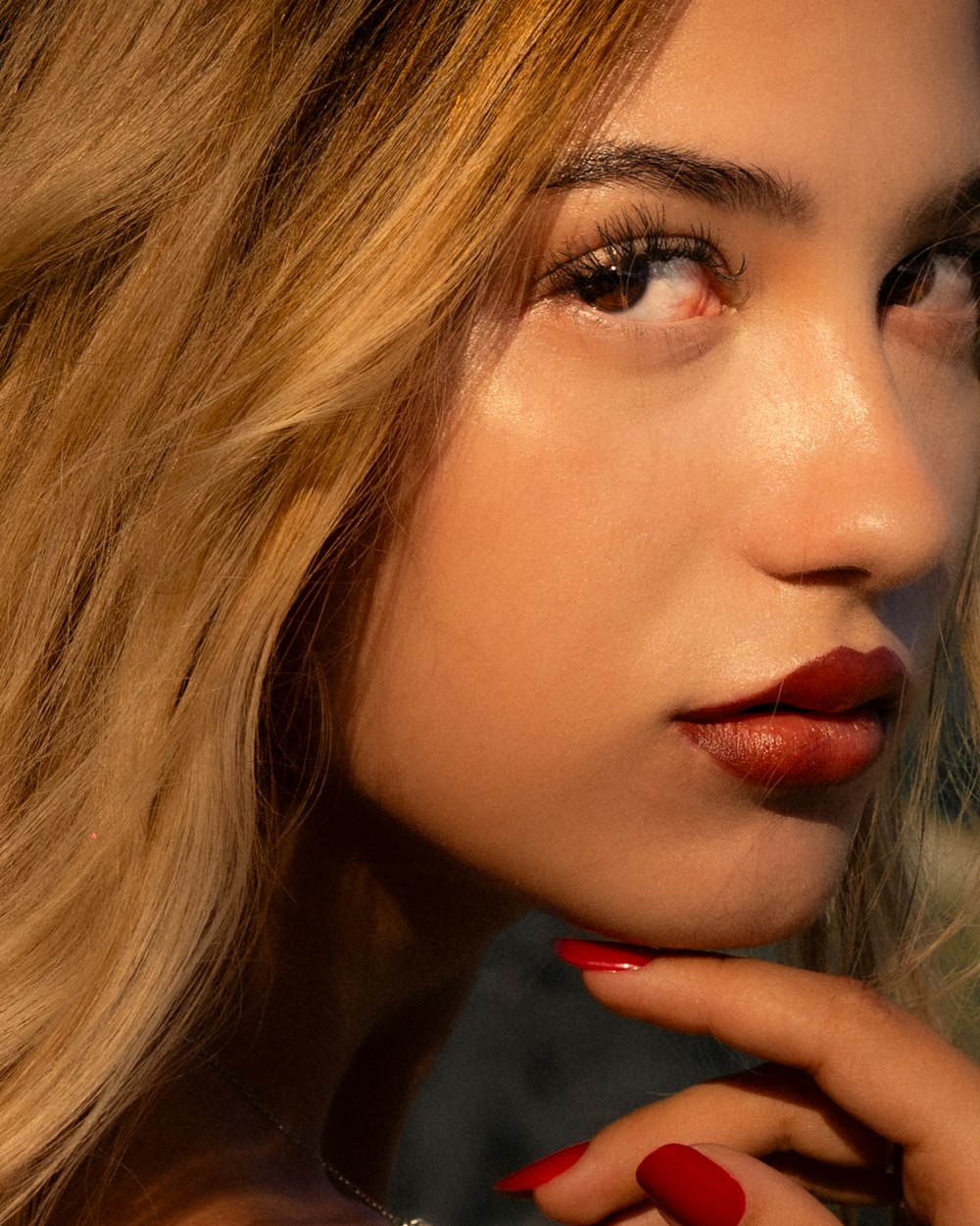 a woman with a red manicure on her nails