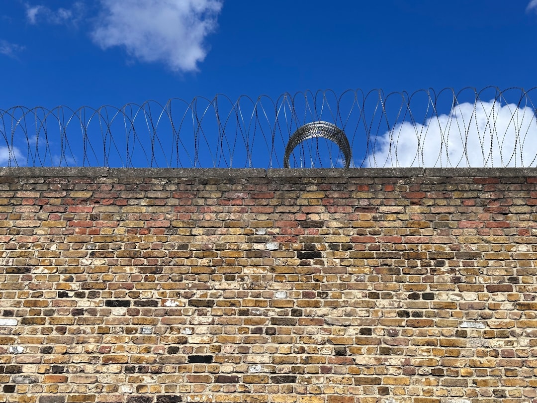 a brick wall with barbed wire on top of it