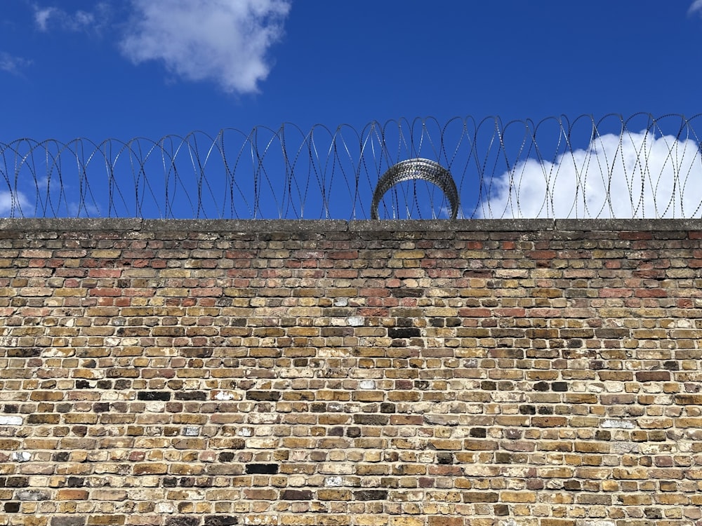 a brick wall with barbed wire on top of it