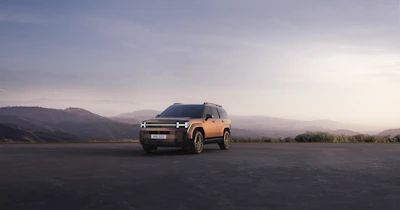 A spacious SUV parked outside a scenic outstation destination.