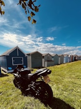 A sleek motorbike parked by a palm tree with a clear blue Bali sky in the background.