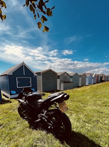 A sleek motorbike parked by a palm tree with a clear blue Bali sky in the background.