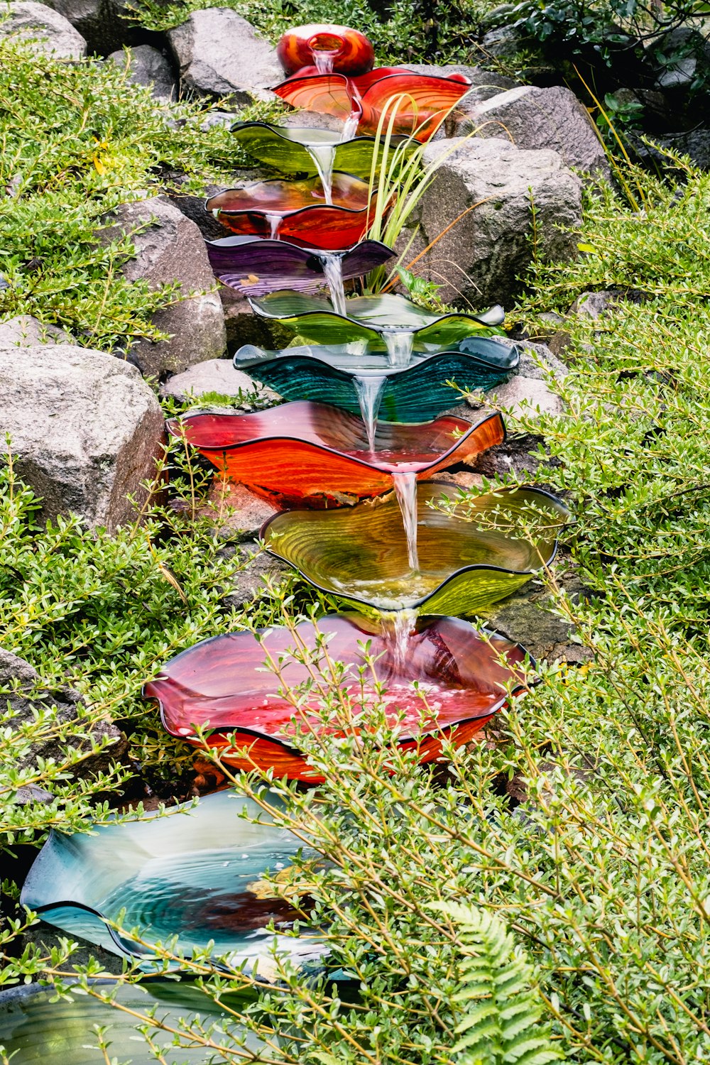 a water fountain made out of glass in a garden