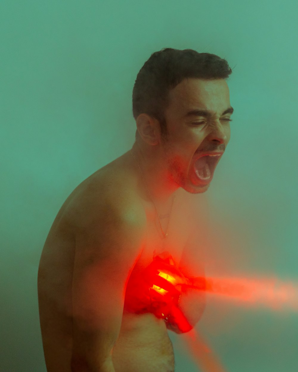 a shirtless man with a laser gun in his hand