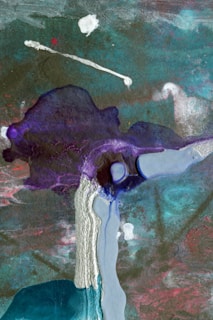 An abstract artwork composed of flowing and layered colors, including shades of teal, purple, and pink. There are dynamic textures suggesting movement, with a blend of dark and light areas. The paint appears to be poured or dripped, creating organic forms and a sense of fluidity.