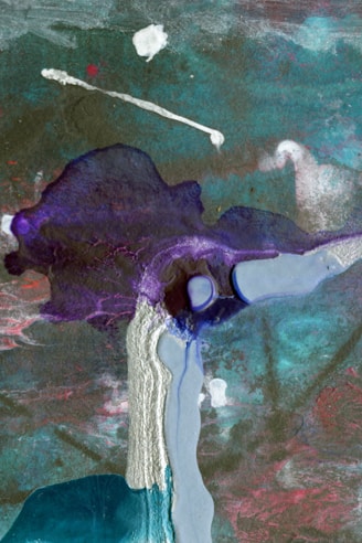 An abstract artwork composed of flowing and layered colors, including shades of teal, purple, and pink. There are dynamic textures suggesting movement, with a blend of dark and light areas. The paint appears to be poured or dripped, creating organic forms and a sense of fluidity.