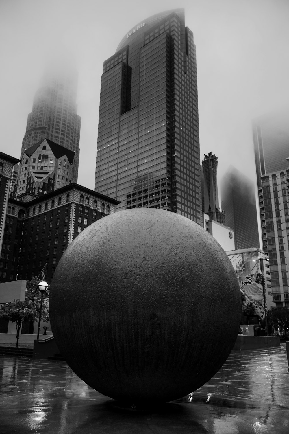 a black and white photo of a large ball in the middle of a city