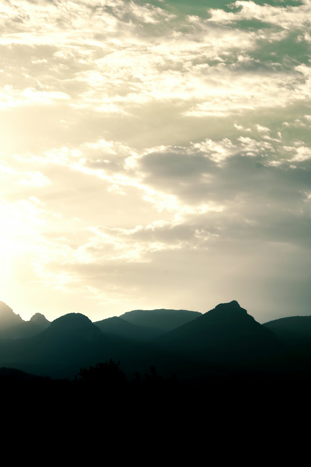 a plane flying in the sky over a mountain range