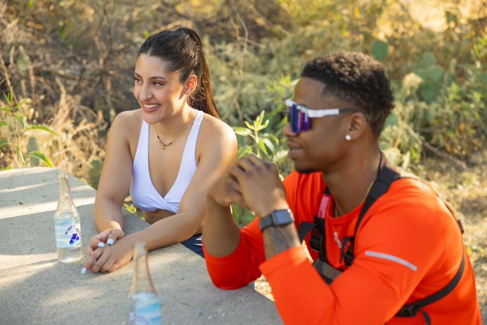 a woman sitting next to a man with a bottle of water