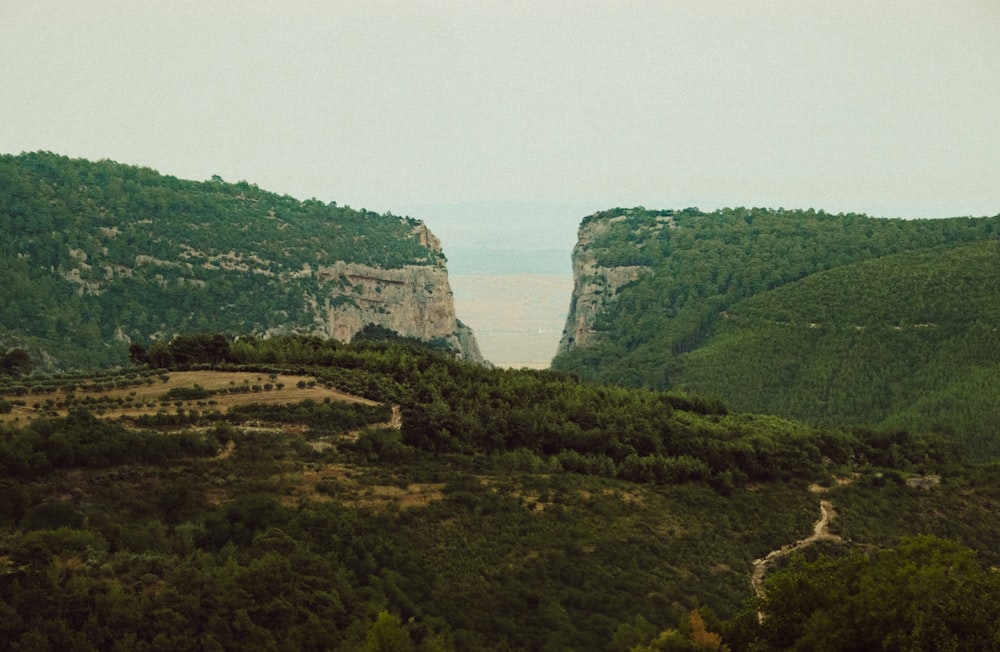 a scenic view of a mountain with a body of water in the distance