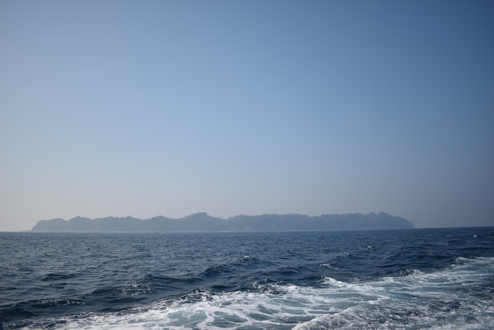 a large body of water with a small island in the distance