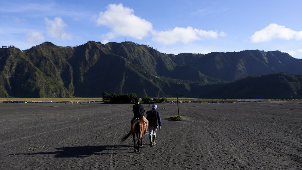 a couple of people riding on the backs of horses