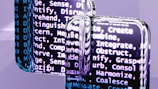 A close-up view of reflective surfaces displaying blurred text with words related to cognitive processes such as create, integrate, and discern. The text is predominantly white and appears on a dark background, creating a high contrast. The reflective surfaces create a distorted and layered effect, adding depth to the image.