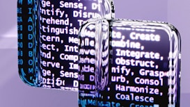A close-up view of reflective surfaces displaying blurred text with words related to cognitive processes such as create, integrate, and discern. The text is predominantly white and appears on a dark background, creating a high contrast. The reflective surfaces create a distorted and layered effect, adding depth to the image.