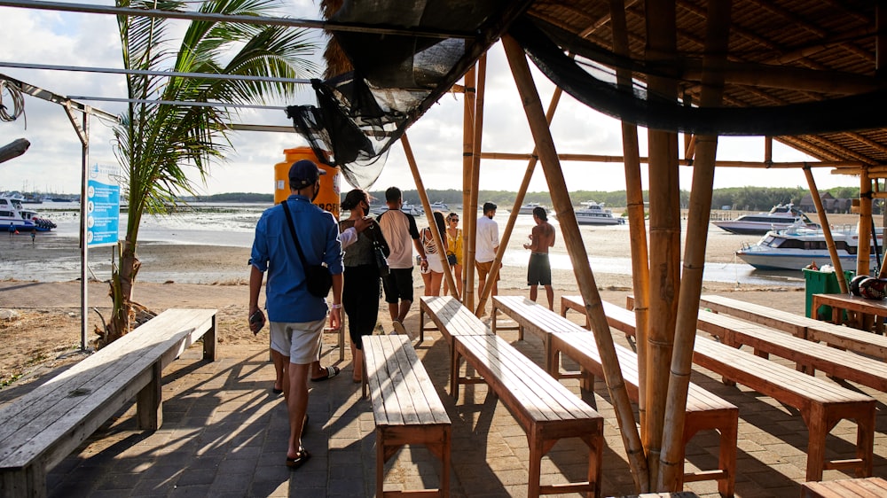 a group of people standing around a wooden bench