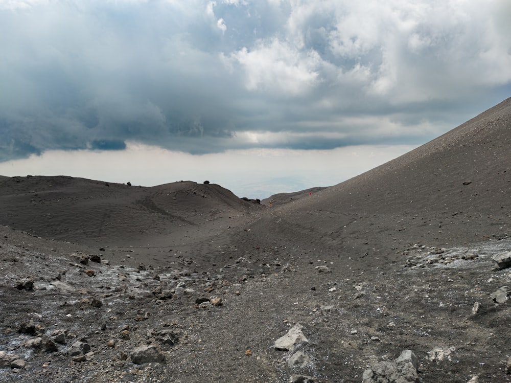 a barren area with rocks and gravel under a cloudy sky