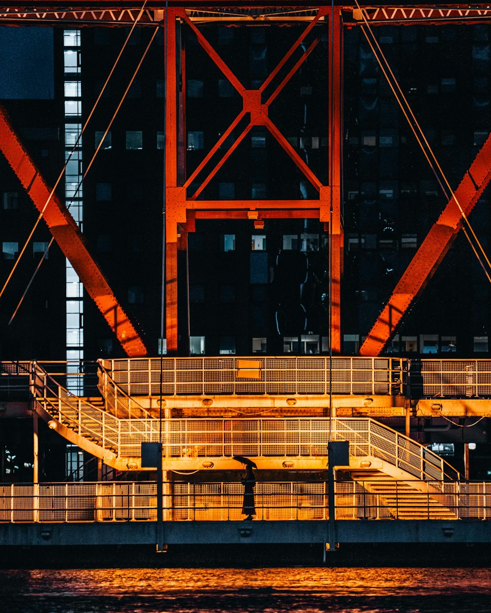 a person is standing on a bridge at night