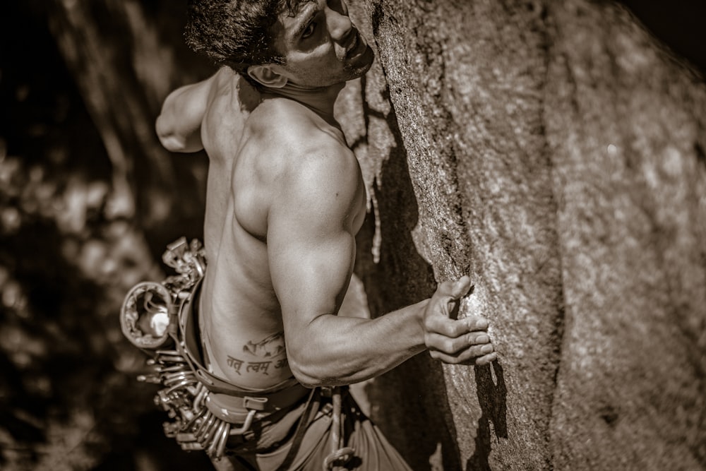 a man climbing up the side of a rock