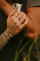 Couple’s matching custom tattoos featuring ancient Egyptian symbols on wrists.