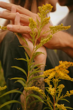 A cinematic close-up of hands intertwined during a quiet moment outdoors.