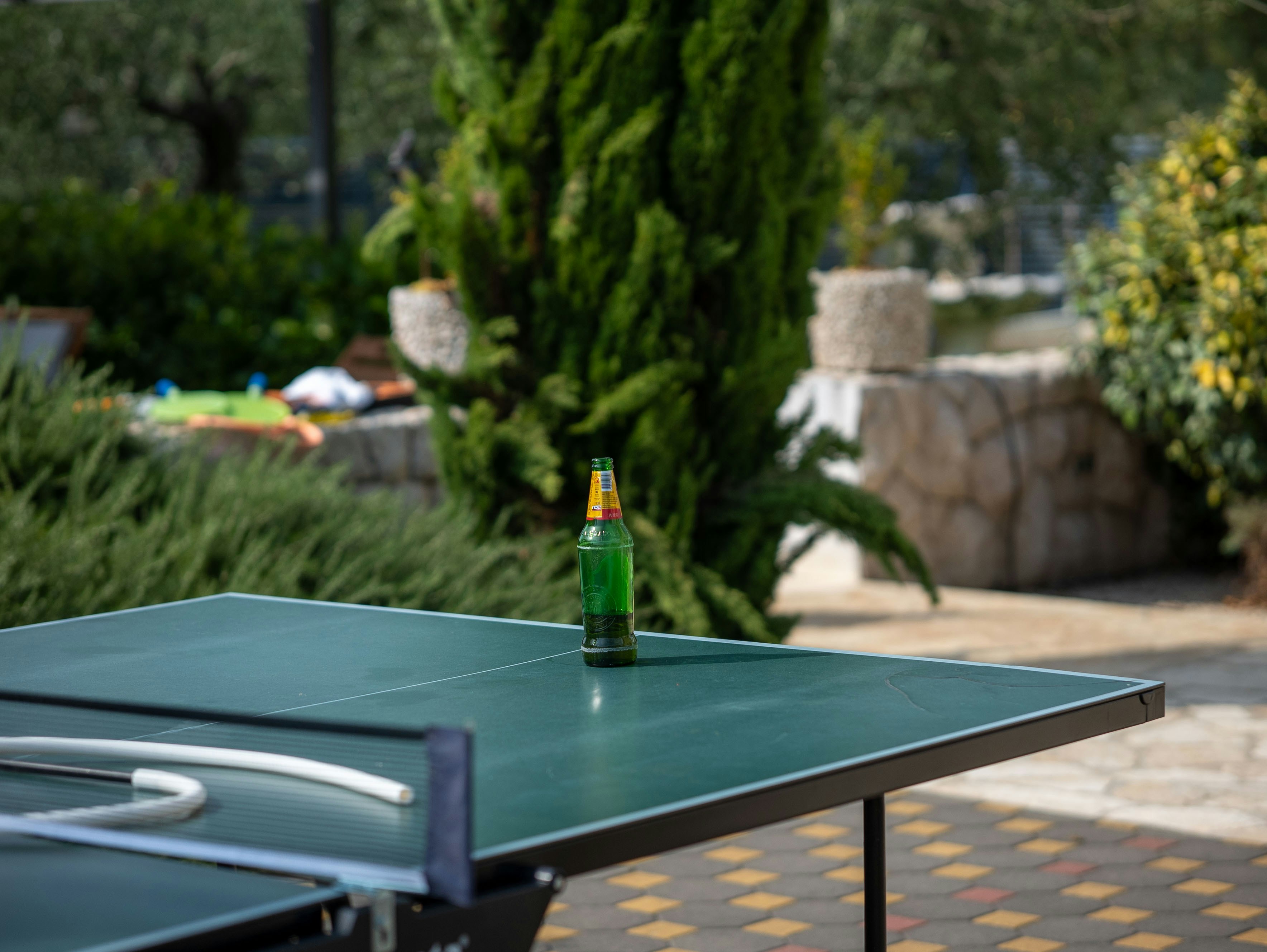 sunset gaming session with friends around outdoor ping pong table - open air game room