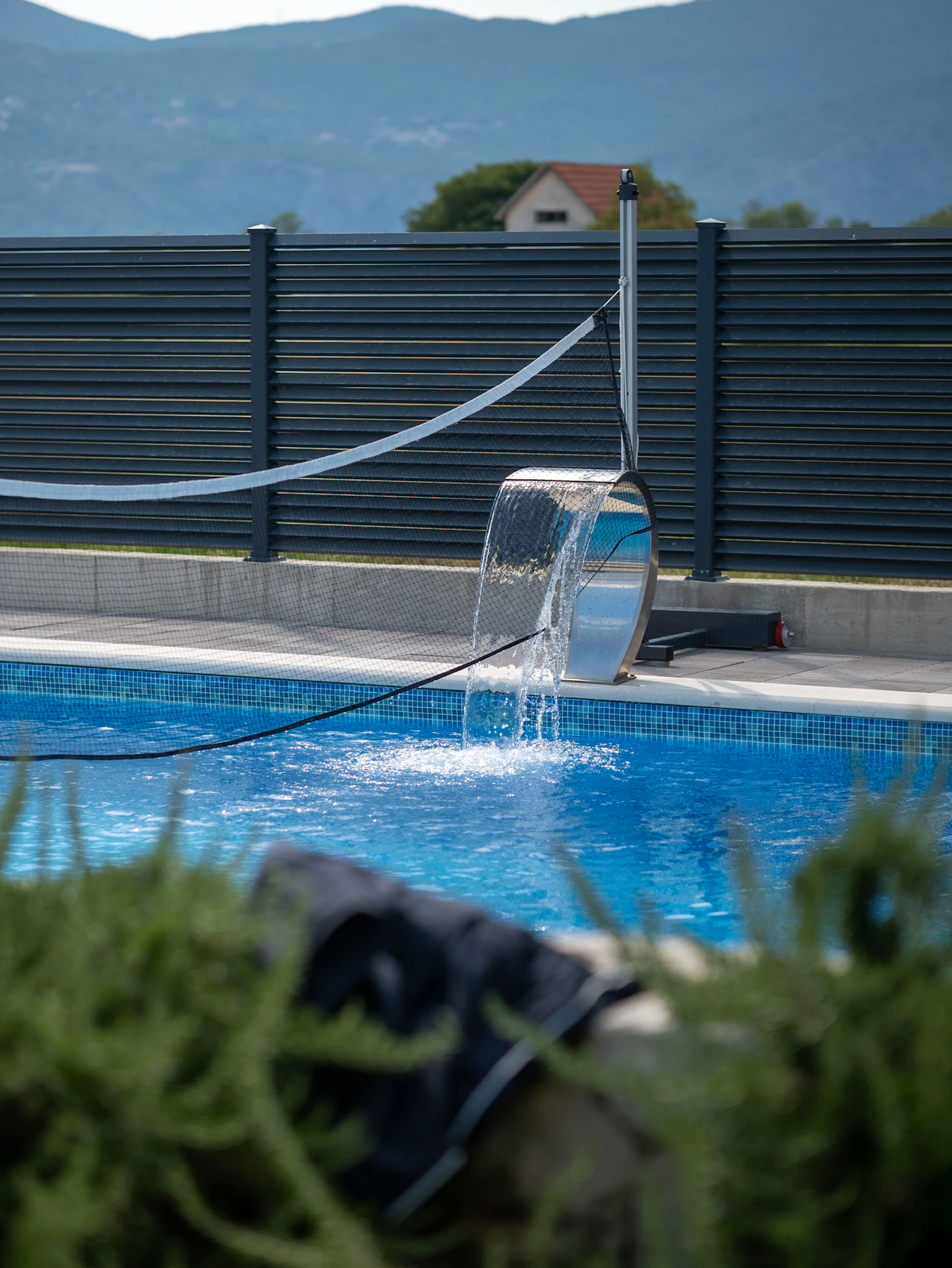 Pool being serviced with a hose along the waterline during a restoration