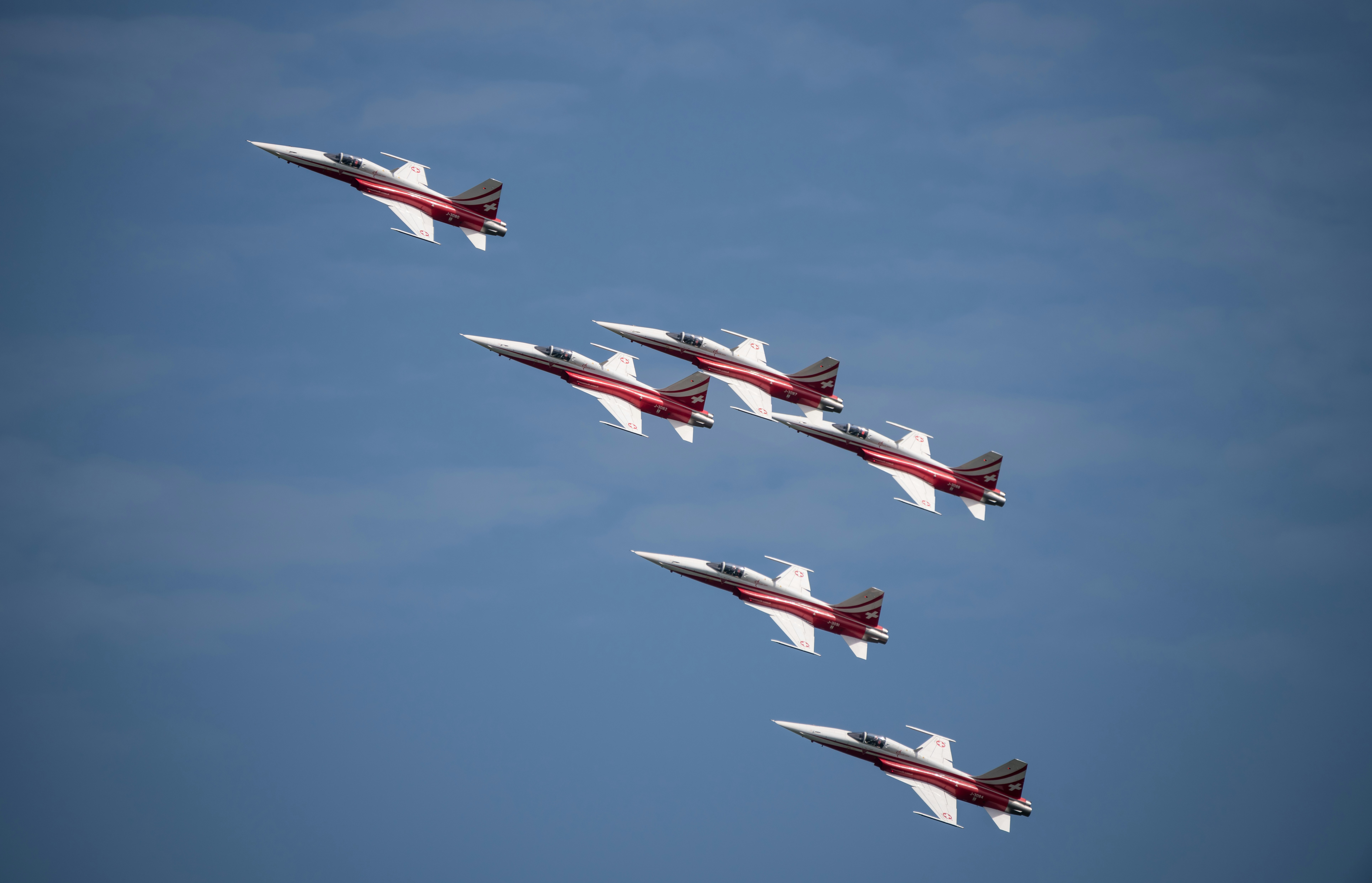 a group of fighter jets flying through a blue sky, Northrop F-5F Tiger II / Patrouille Suisse