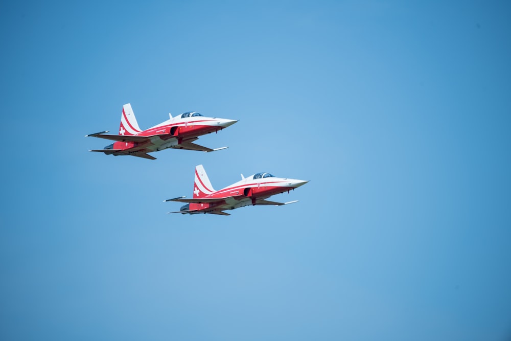 two red and white jets flying in the sky