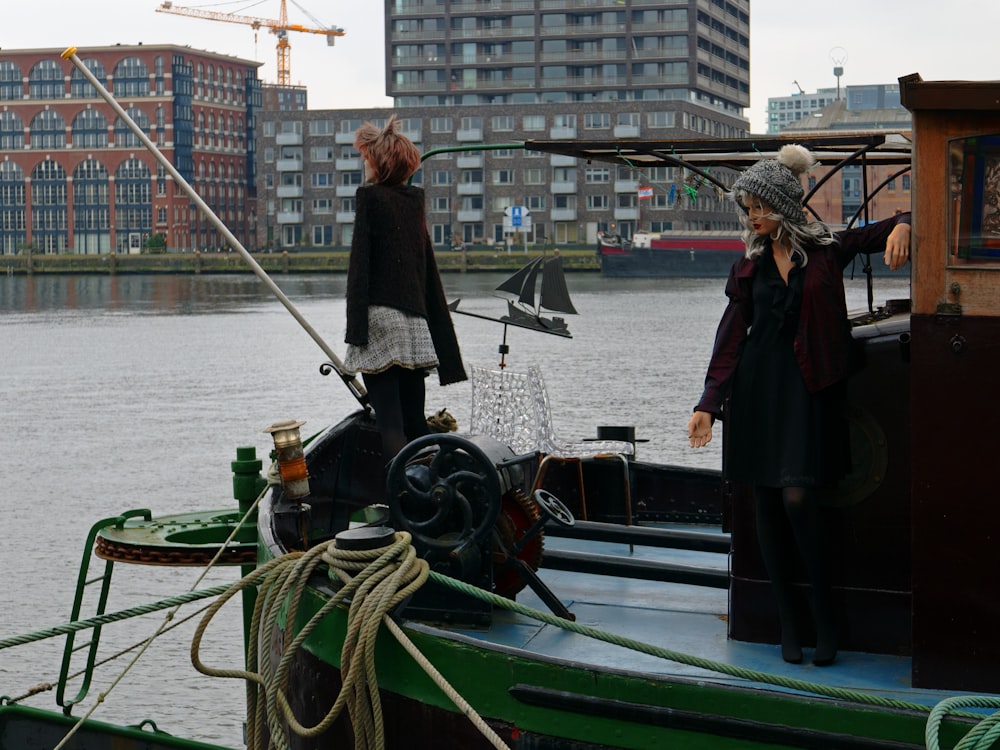 two people standing on a boat in the water