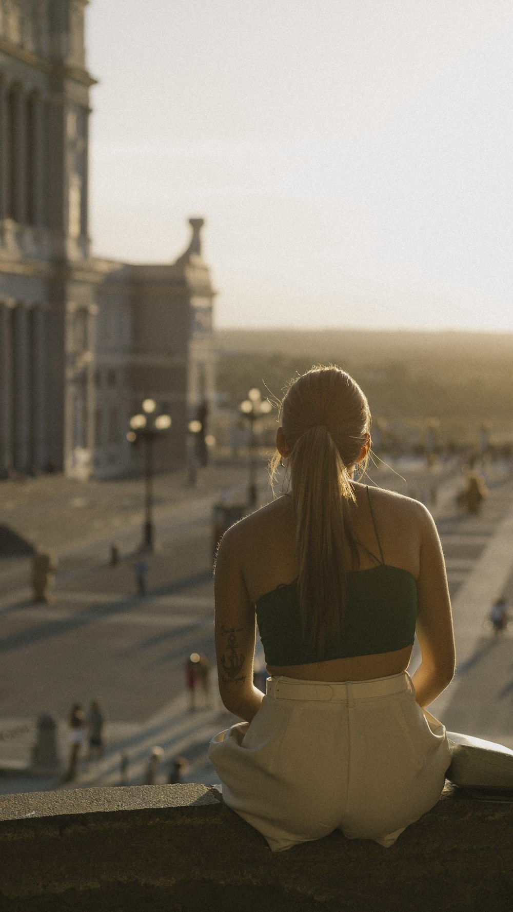 a woman sitting on a ledge in front of a building