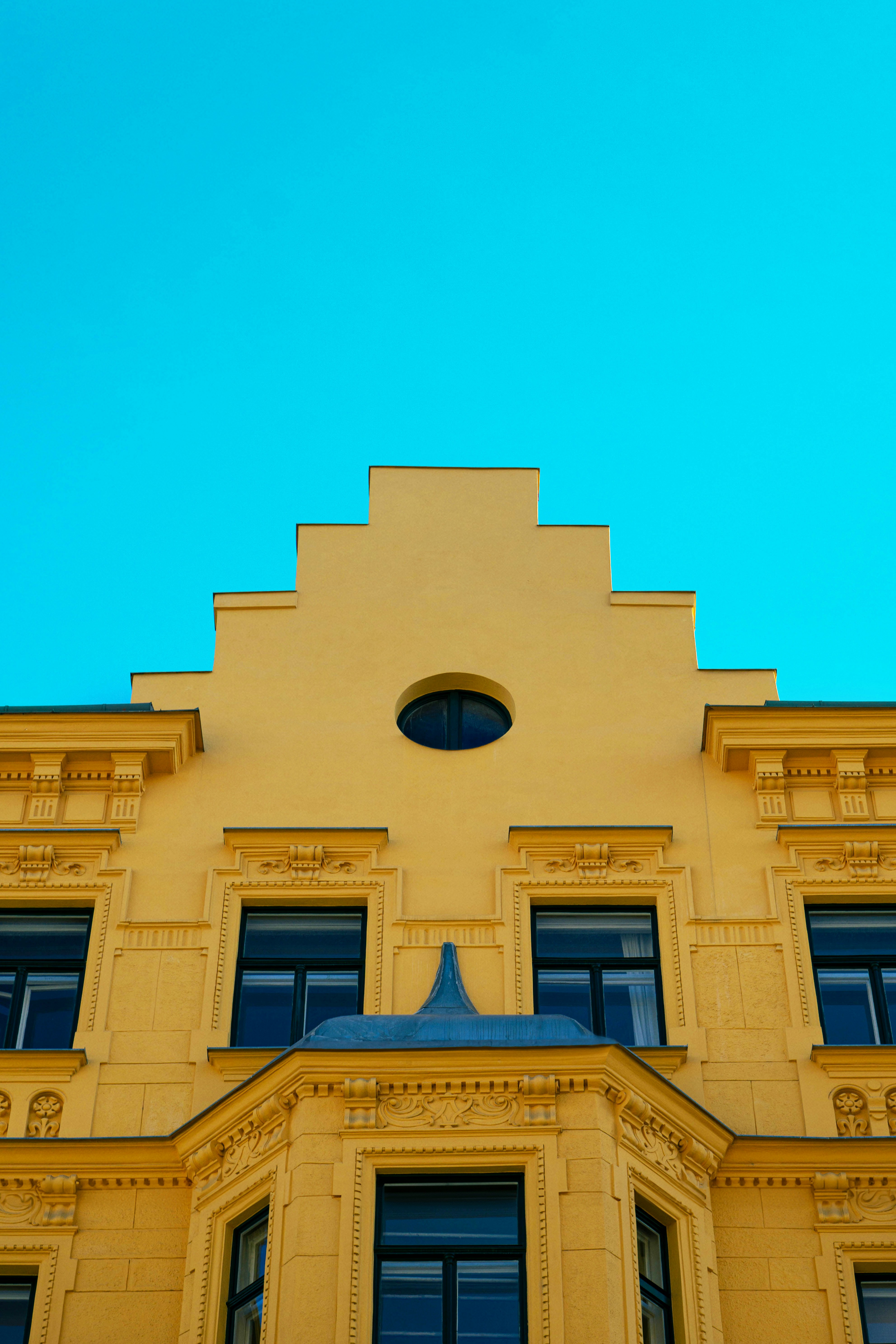 a yellow building with a blue sky in the background