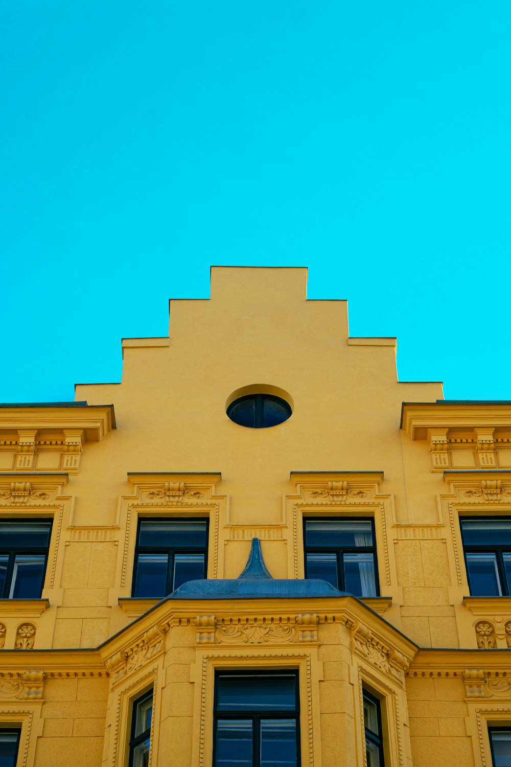 a yellow building with a blue sky in the background