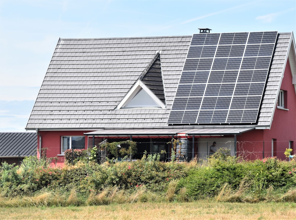 a red house with solar panels on the roof
