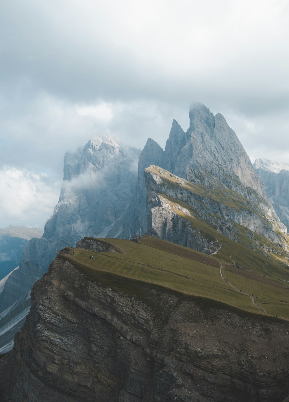 a mountain with a grassy field below it