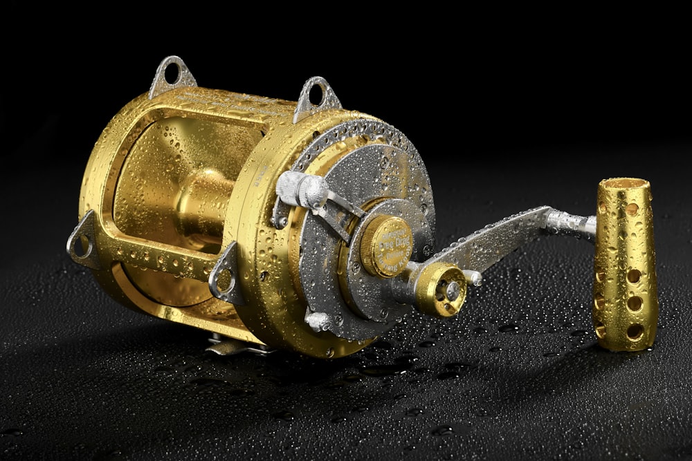 a close up of a fishing reel on a black surface