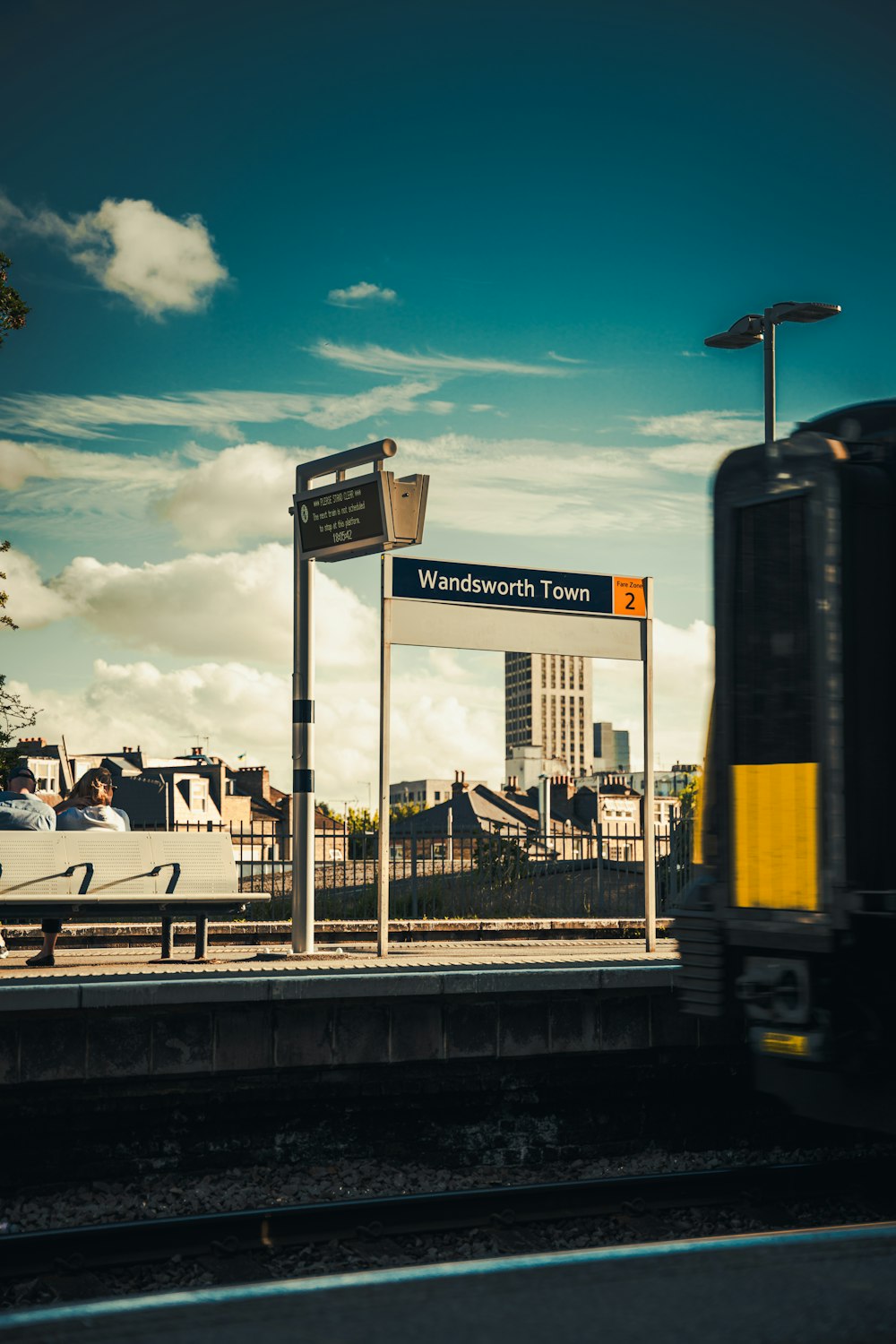 a train traveling past a train station next to a tall building