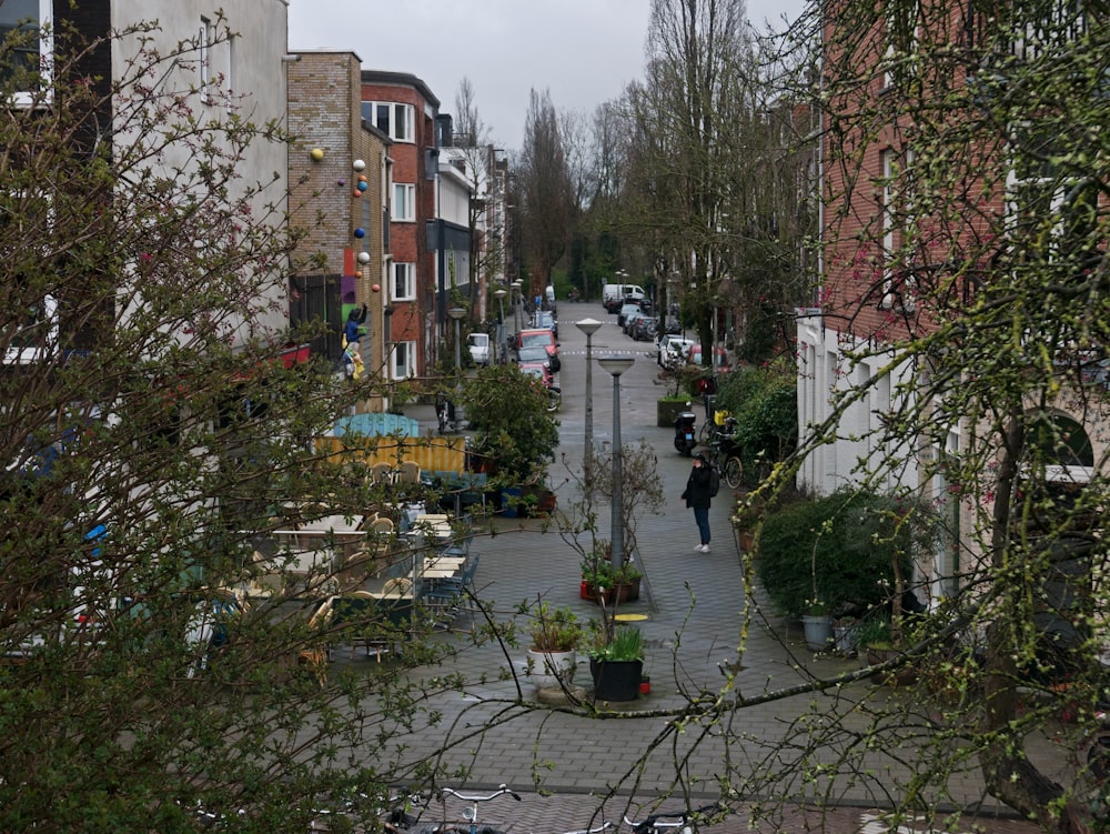 a man walking down a street next to tall buildings