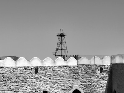 A high-contrast image of a fortress wall with sharp shadows and textured stone.