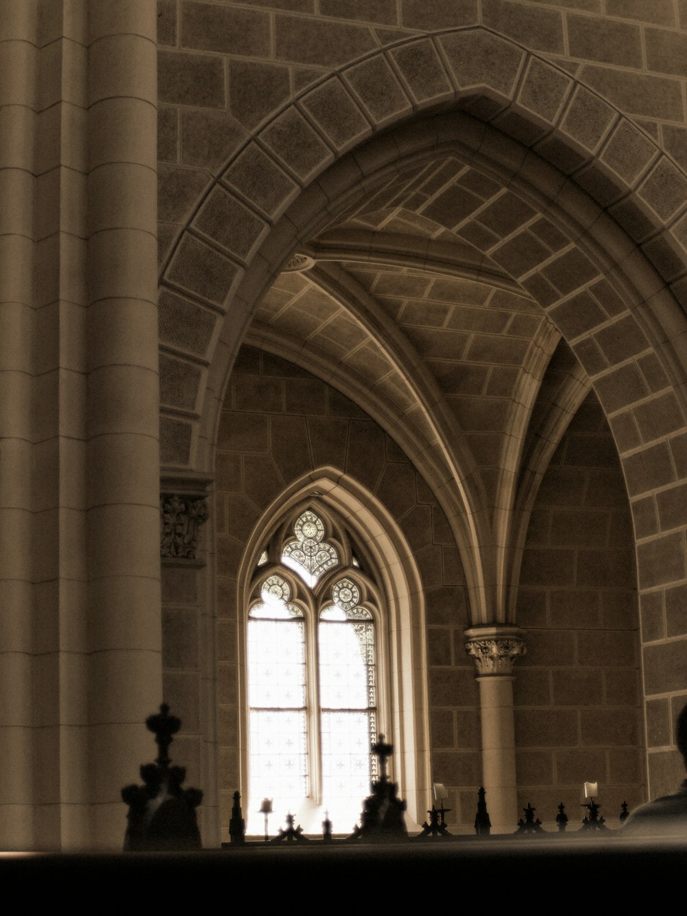 a church with a large arched window and a clock on the wall