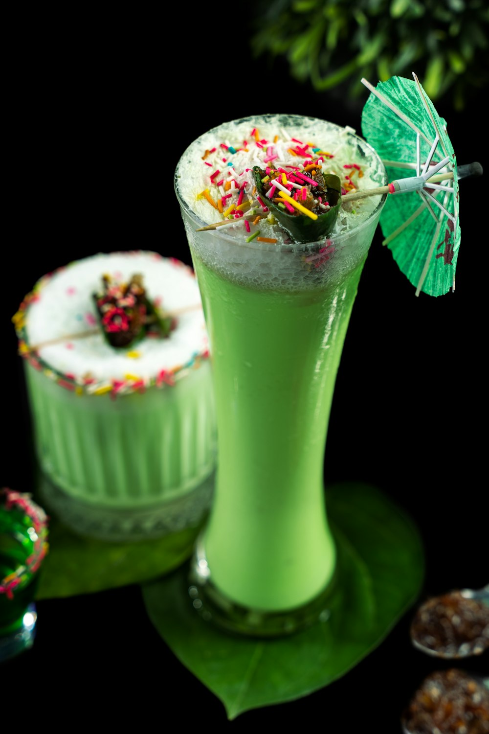 a green drink with sprinkles and a green umbrella