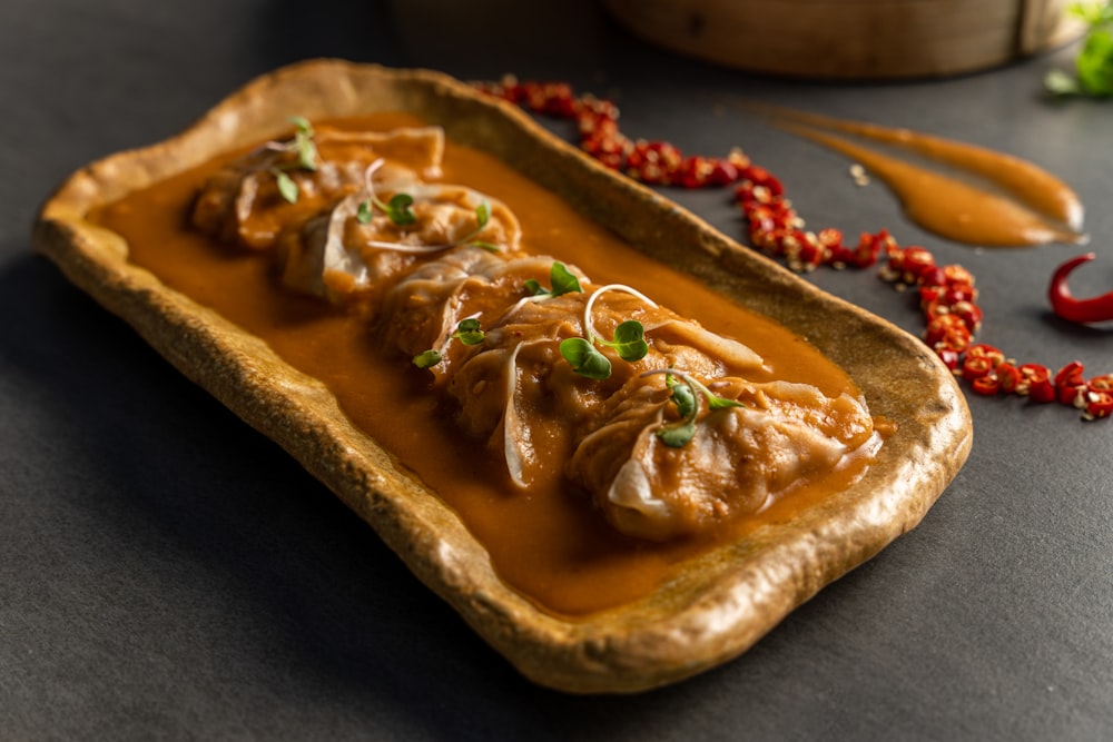 a dish of food with sauce and garnishes on a table