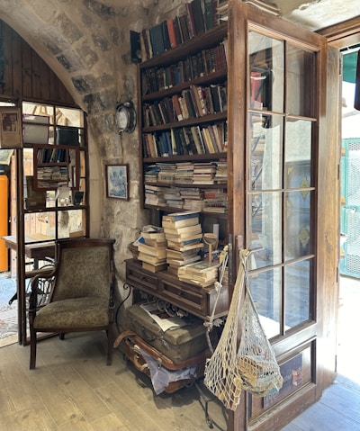 A cozy living room corner featuring a creatively rearranged vintage armchair and a small bookshelf filled with personal mementos.