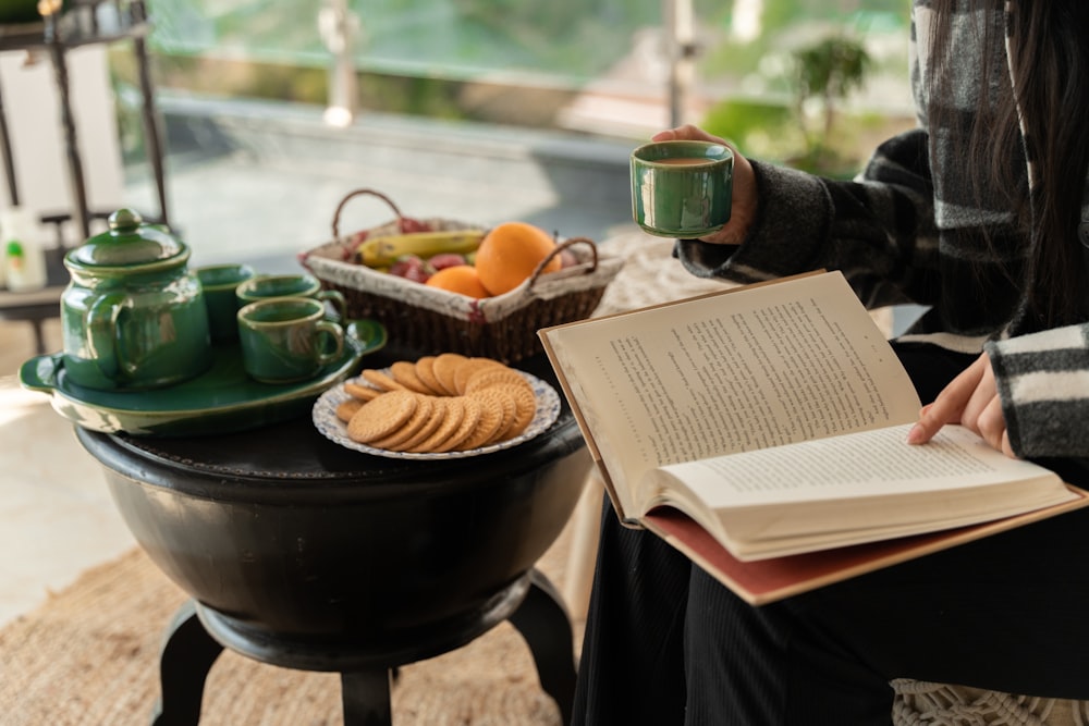 a woman holding a book and a cup of coffee