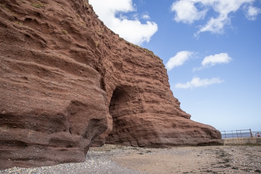 a large rock formation on a beach next to the ocean